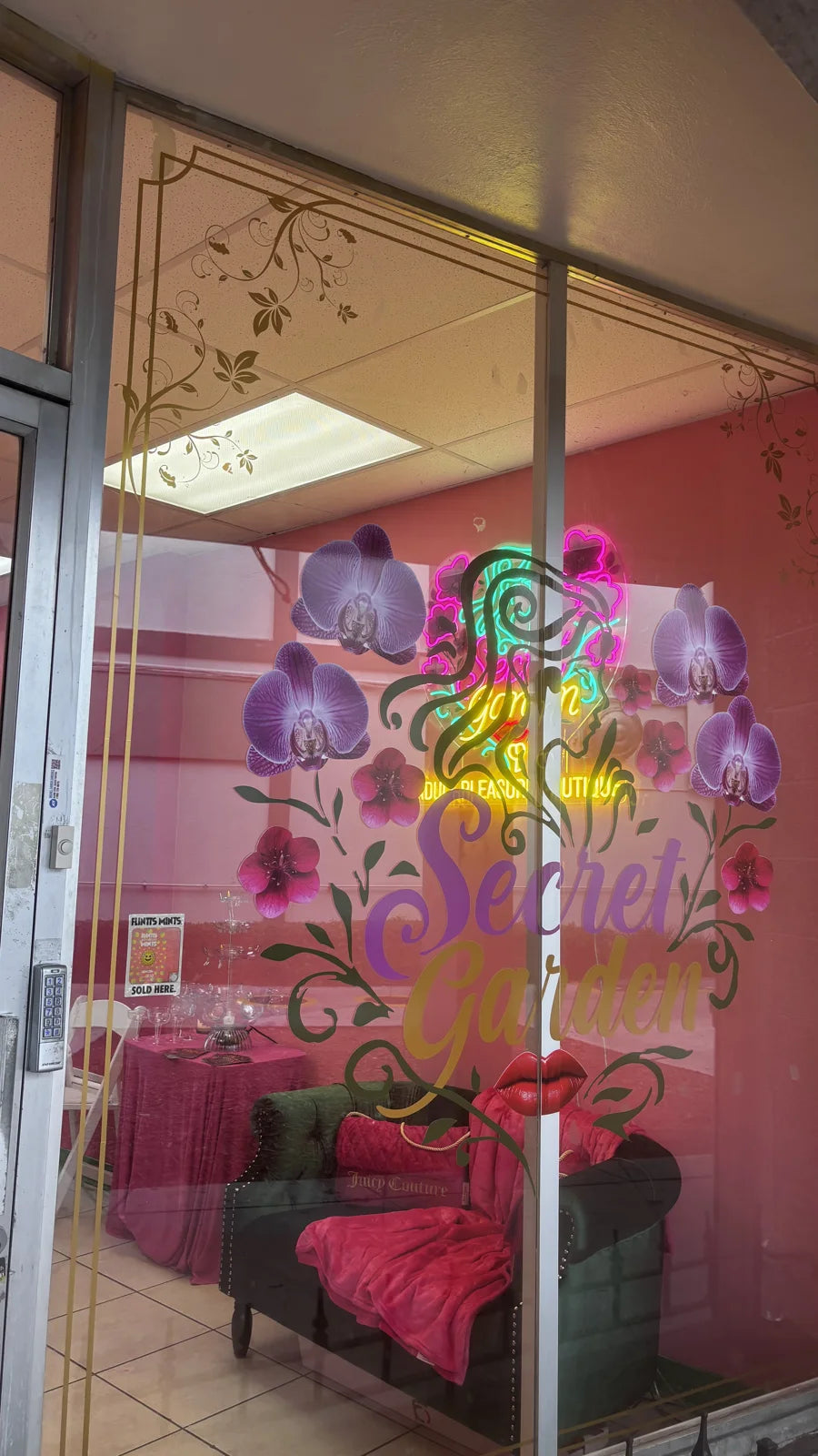 Glass entrance to Secret Garden with the colorful boutique logo